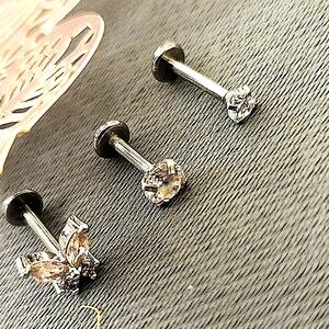 Three silver color stud piercings